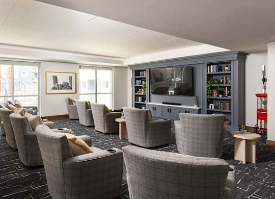 A room with grey chairs and a television.