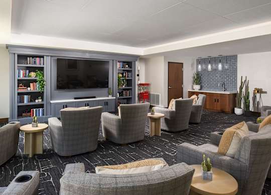 A living room with grey couches and a television.