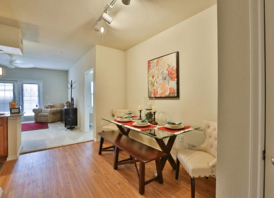 a dining room with a table and chairs and a living room at Cedars of Elk Drive 55+ Apartments, Burleson, 76028