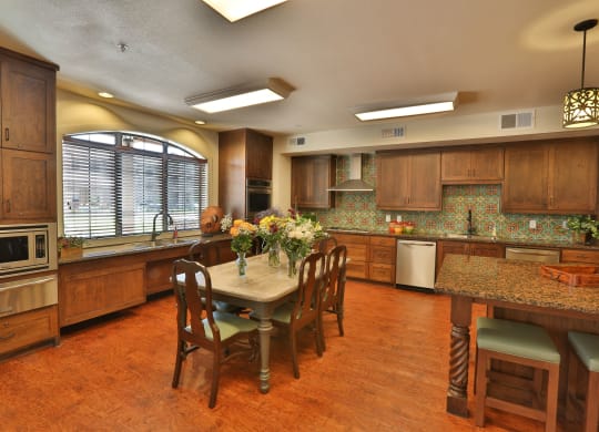 a large kitchen with a large island and a table with chairs at Cedars of Elk Drive 55+ Apartments, Burleson, TX 76028