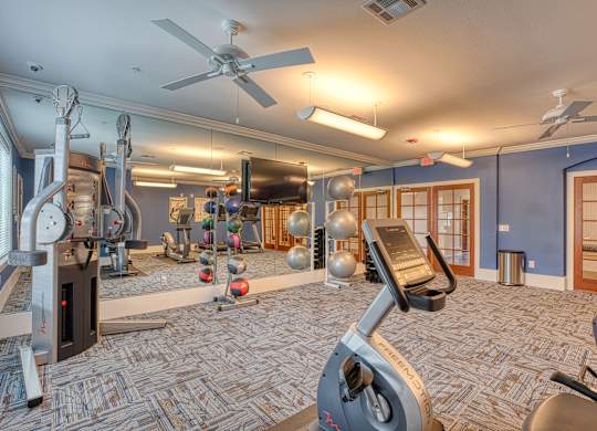 a home gym with a ceiling fan and exercise equipment at Mariposa at South Broadway, Joshua