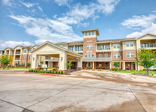 an apartment building with an empty parking lot at Mariposa at South Broadway, TX 76058