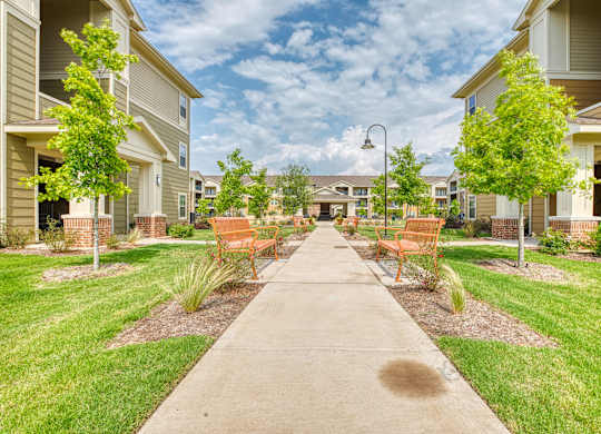 the preserve at ballantyne commons walkway with benches and trees at Mariposa at South Broadway, Joshua Texas