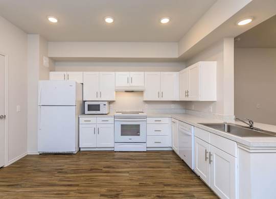 a white kitchen with white cabinets and white appliances at Mariposa at Westchester, Grand Prairie