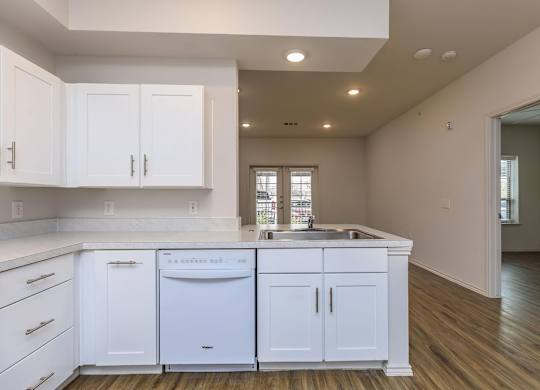 a kitchen with white cabinets and a sink and a dishwasher at Mariposa at Westchester, Grand Prairie Texas