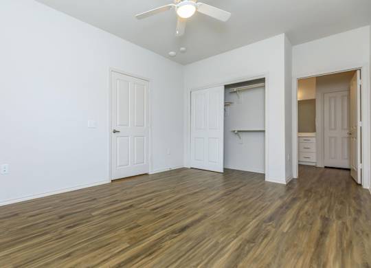 an empty living room with white walls and a ceiling fan at Mariposa at Westchester, Texas