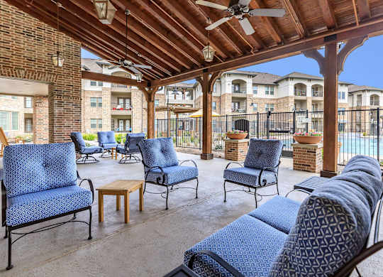 a patio with chairs and a ceiling and a pool at Mariposa at Westchester, Texas, 75052
