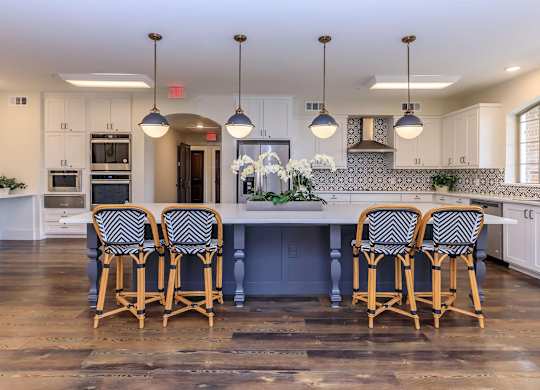 a large kitchen with a large island and chairs at Mariposa at Westchester, Texas