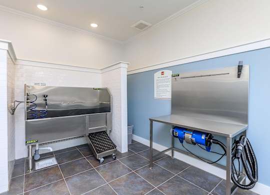 a laundry room with a stainless steel refrigerator and a sink at Mariposa at Westchester, Grand Prairie, TX