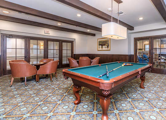a pool table in a game room with chairs at Mariposa at Westchester, Texas 
