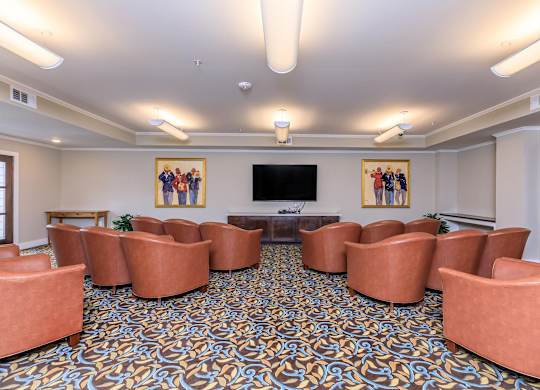 a conference room with couches and a table in front of a television at Mariposa at Westchester, Grand Prairie Texas