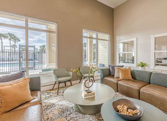 A living room with a couch, chairs, and a coffee table with a bowl of pretzels on it.
