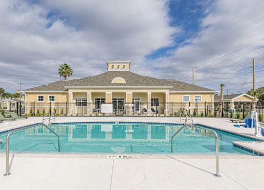 A large building with a pool in front of it.