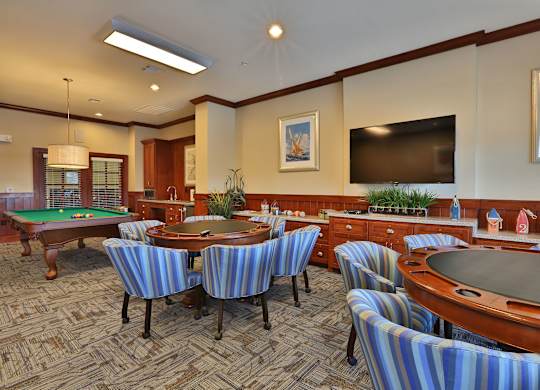a billiards room with tables and chairs and a television