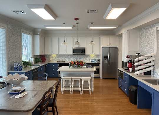 a large kitchen with blue and white cabinets and stainless steel appliances