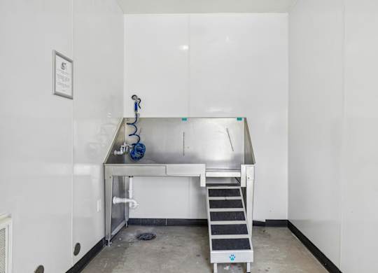 A clean, empty room with a stainless steel table and a metal staircase.