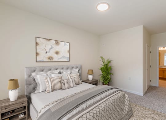 A bedroom with a large bed and a window with a view of a balcony.