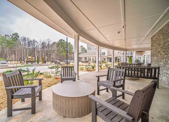 A patio with a table and chairs under a roof.