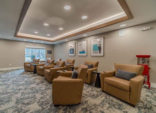 A waiting room with tan chairs and a carpet.
