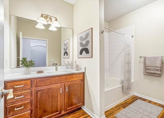 A bathroom with a wooden vanity and a walk-in shower.
