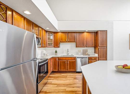 A modern kitchen with wooden cabinets and stainless steel appliances.
