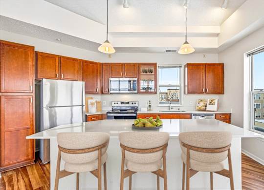 A kitchen with a white countertop and wooden cabinets.