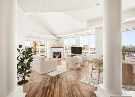 A living room with white furniture and a wooden floor.