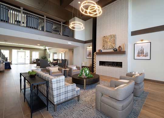A modern living room with a fireplace and a large grey sofa.