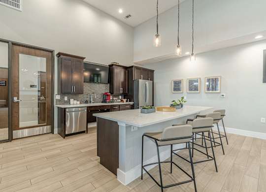 A modern kitchen with a large island and bar stools.
