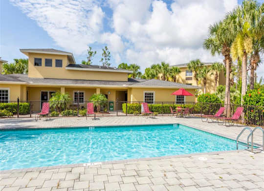 A large house with a pool in front. at Heron Pond 55+ Apartments, Lehigh Acres, FL