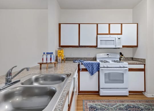 a kitchen with a sink and a stove and a microwave at Mariposa at Bay Colony, Dickinson Texas