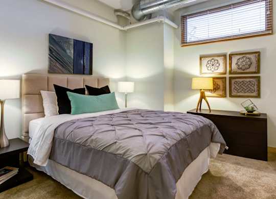 Bedroom with large bed and nightstand at Arcade Apartments, St Louis, 63101