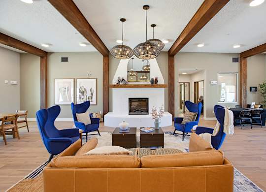 A living room with a fireplace and blue chairs.