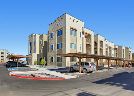 A parking lot in front of a multi-story building.