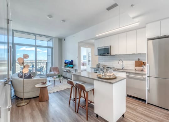 A modern kitchen with a refrigerator, sink, and cabinets.