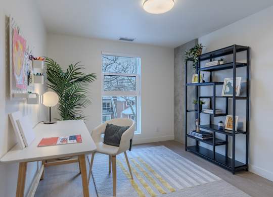 A room with a desk, chair, and bookshelf.