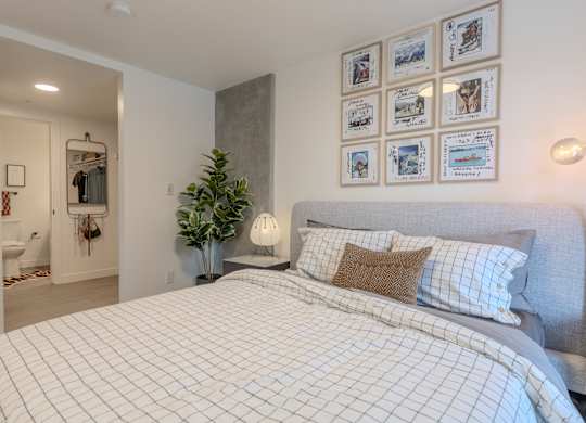 A bedroom with a large bed and pictures on the wall.