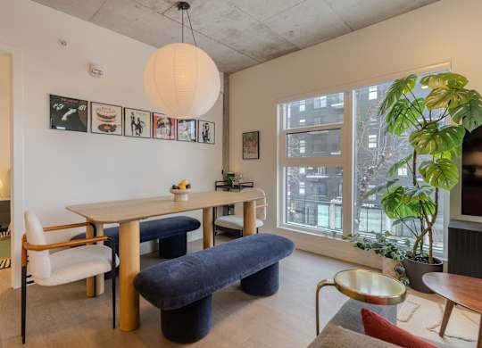 A living room with a white table and blue ottoman.