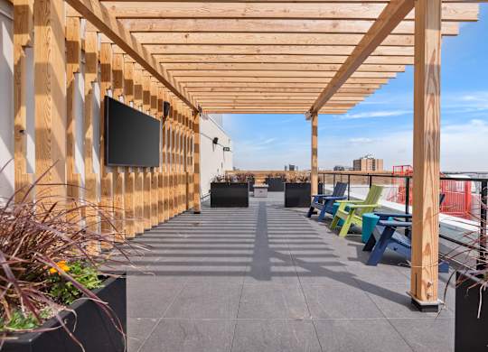 A wooden pergola with a flat screen TV mounted on it.