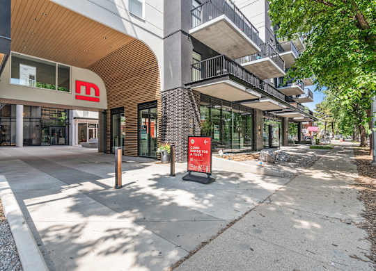 A modern building with a red sign in front of it.