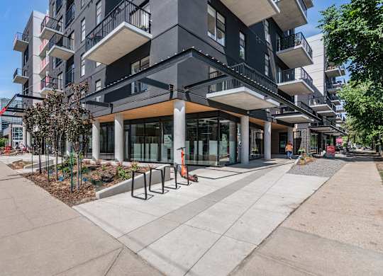 A modern apartment building with a walkway in front.