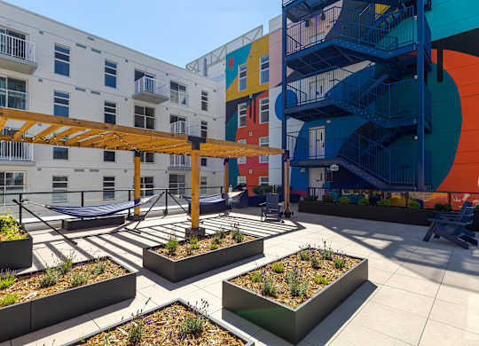 A colorful building with a spiral staircase and a patio with planters.