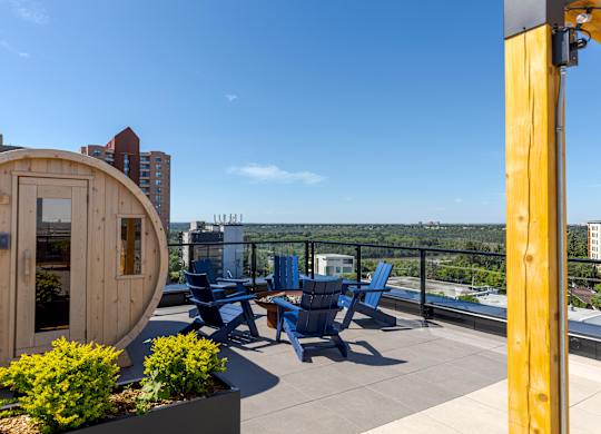 A wooden deck with blue chairs and a table.