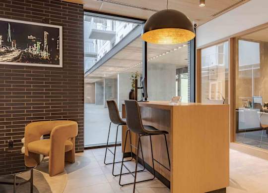 A modern interior with a wooden reception desk and chairs.