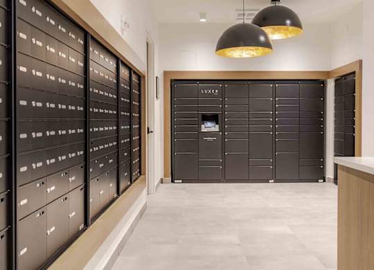 A hallway with a row of black filing cabinets on the left and a row of black lockers on the right.