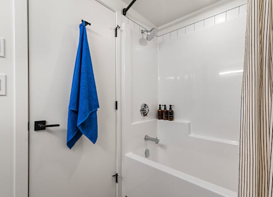 A blue towel is hanging on a black door handle.