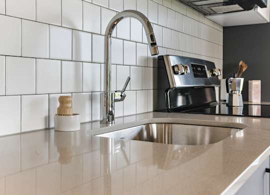 A kitchen with a sink and a black stove.