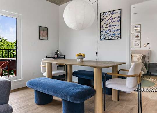A dining room with a wooden table and chairs.