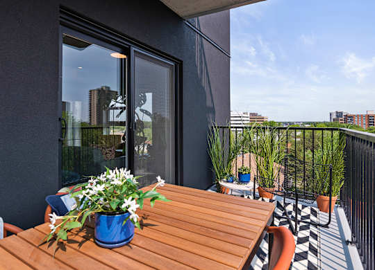 A balcony with a table and chairs and a view of the city.