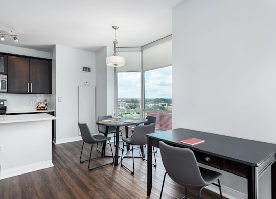 A modern kitchen with dark wood floors and white walls at Clayton on the Park Apartments, Clayton, MO